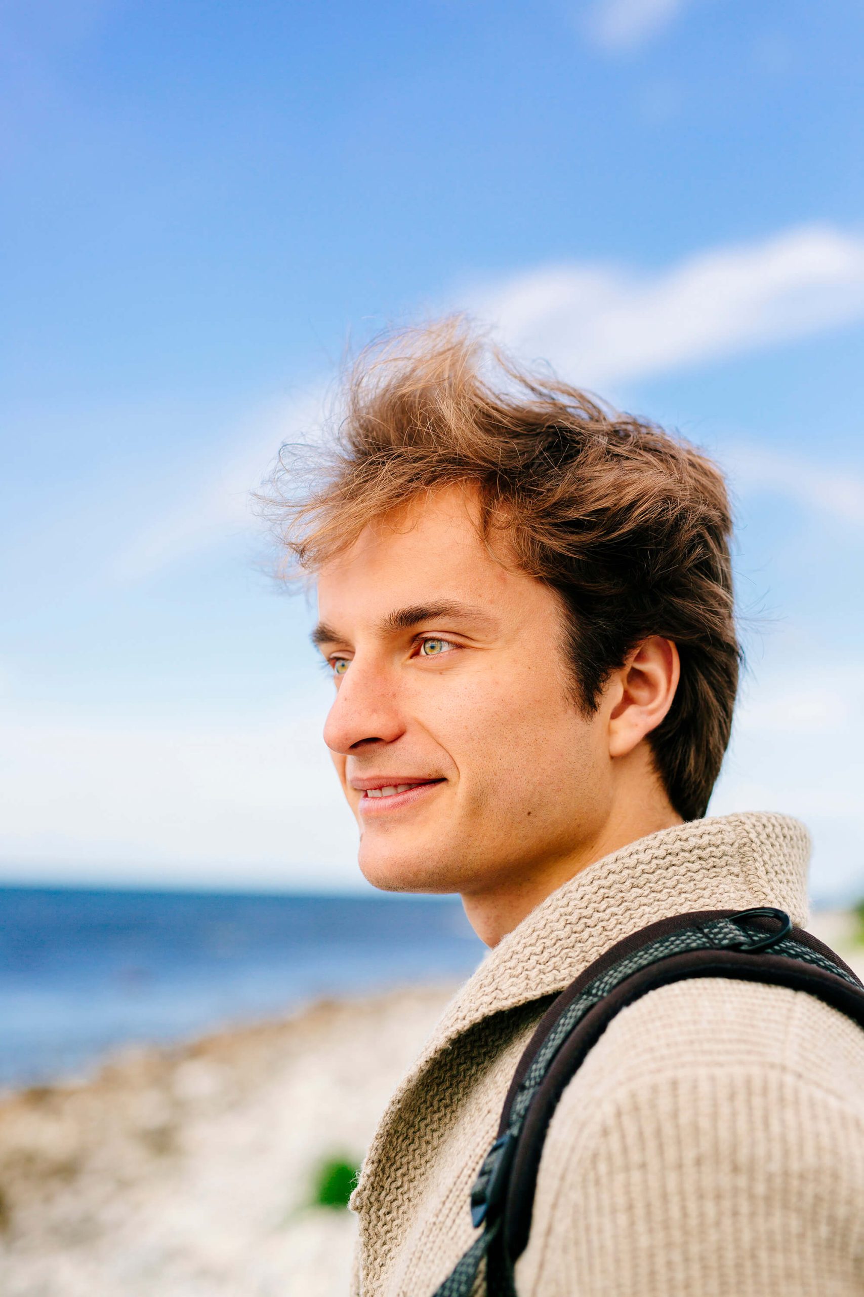 happy-man-smiling-while-standing-on-beach-against-DANCP25.jpg